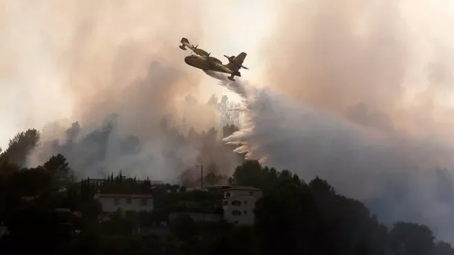 Пожарный самолет пытается погасить лесной пожар в районе Ниццы.