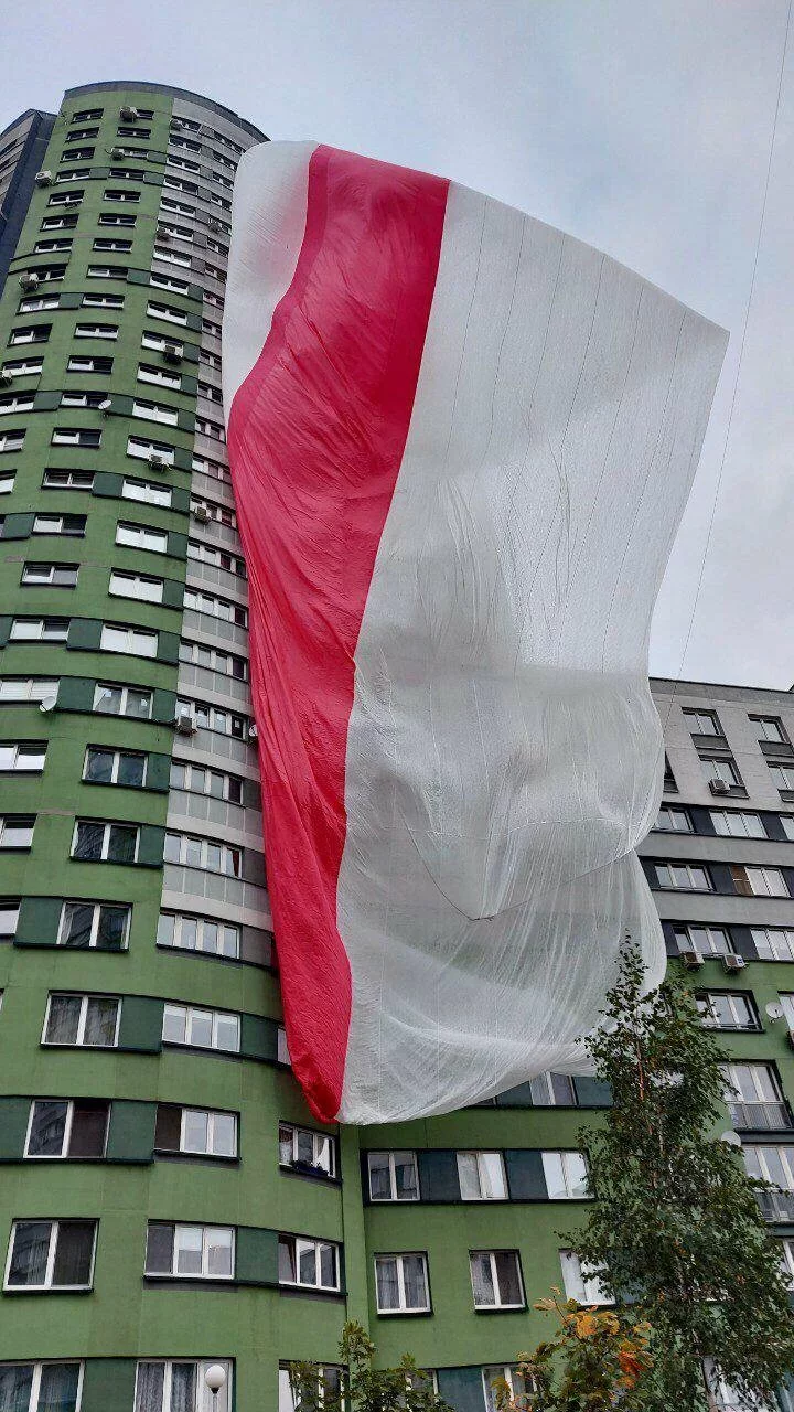 На фото: жители «Каскада» вывешивают гигантский белорусский флаг, 2020 год.