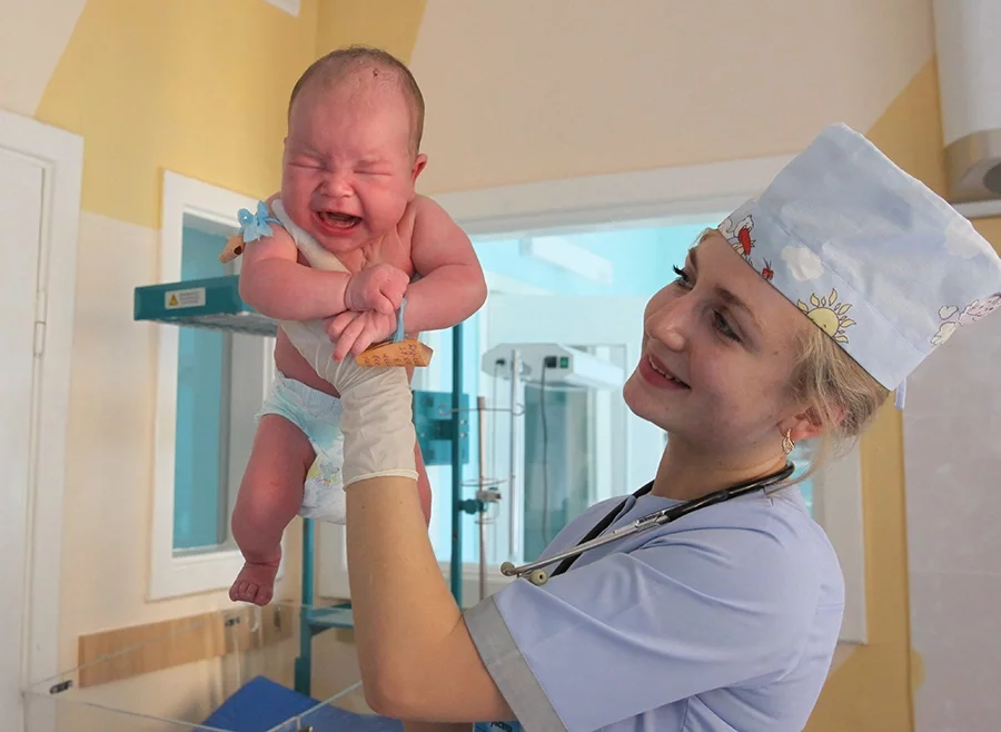 Богатырь Савелий Дулинец в руках заведующей отделением новорожденных детей Анны Яроцкой. Фото: БелТА.