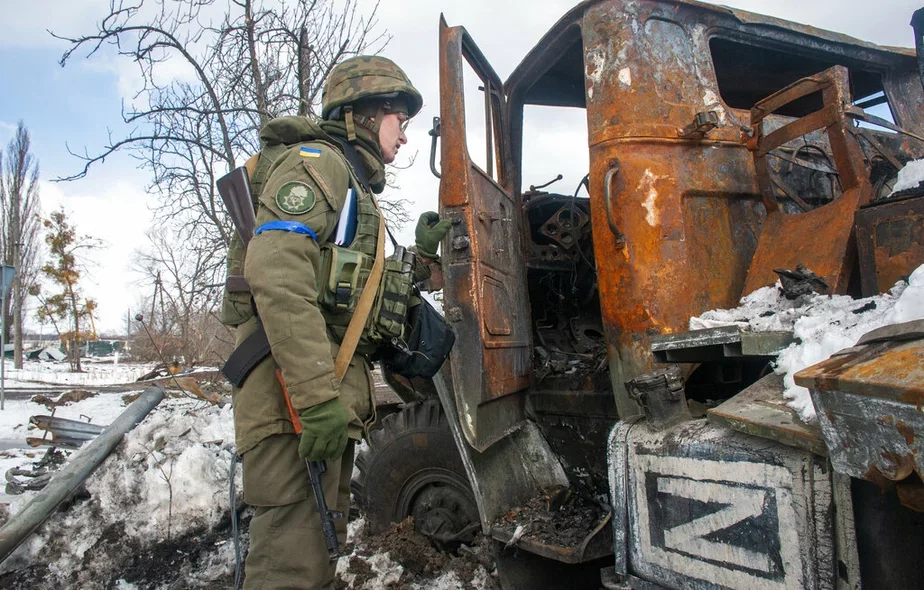 Боец Национальной гвардии Украины осматривает поврежденную российскую военную машину в Харькове. 16 марта 2022 года. Фото: AP / Andrew Marienko.